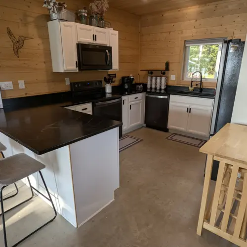 Éclairage encastré et meubles de cuisine modernes dans notre cuisine entièrement équipée, créant un espace lumineux et accueillant pour cuisiner dans la maison au bord du lac.